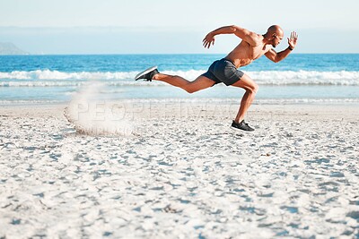 Buy stock photo Shot of a young man sprinting on the beach