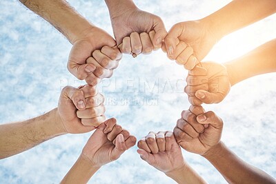 Buy stock photo Hands in circle, fist and blue sky, community in collaboration for support and diversity together from below. Teamwork, power hand sign and sunshine, positive group of people in solidarity and huddle