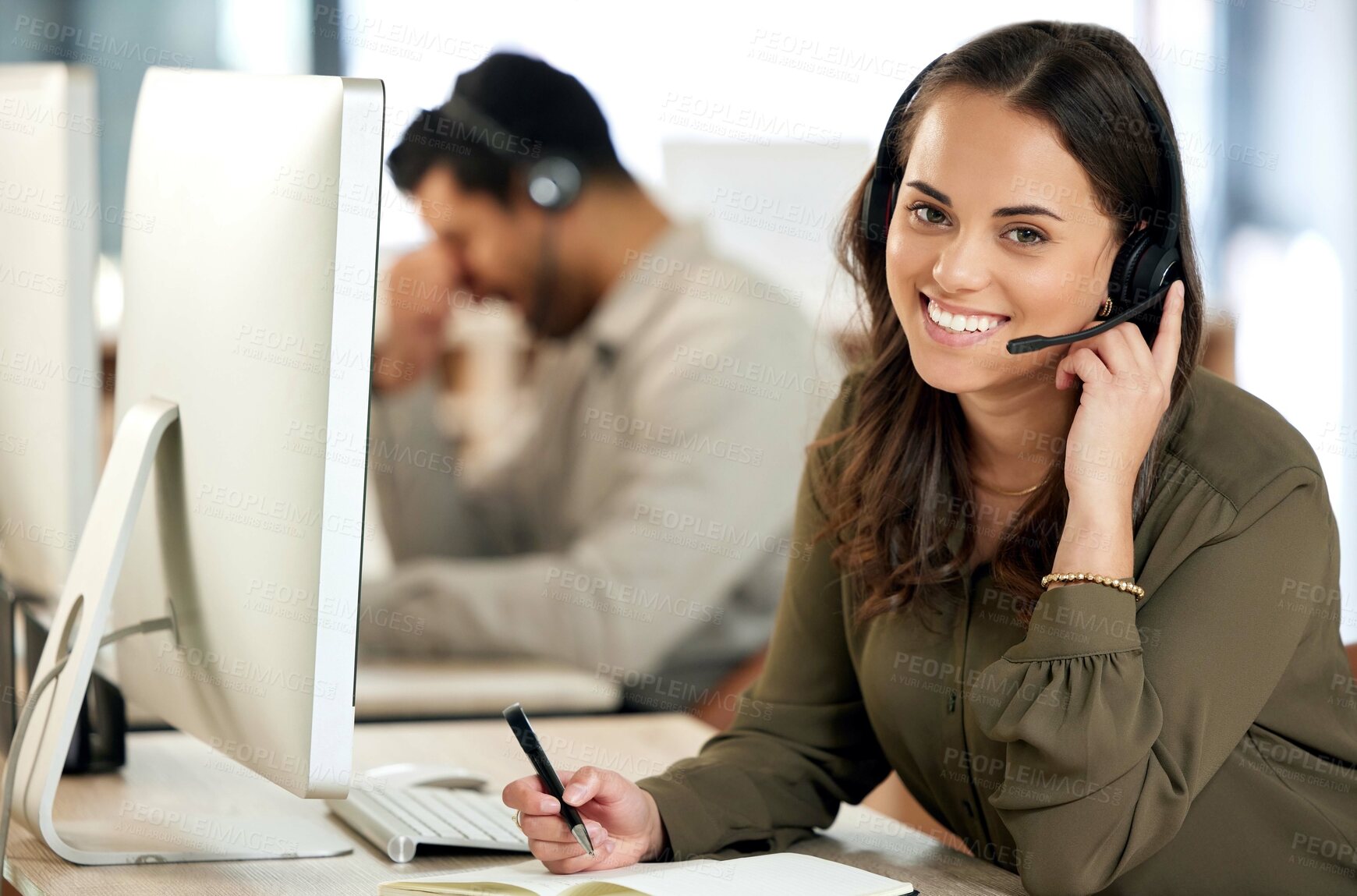 Buy stock photo Portrait of a young businesswoman using a headset and writing in a notebook in a modern office