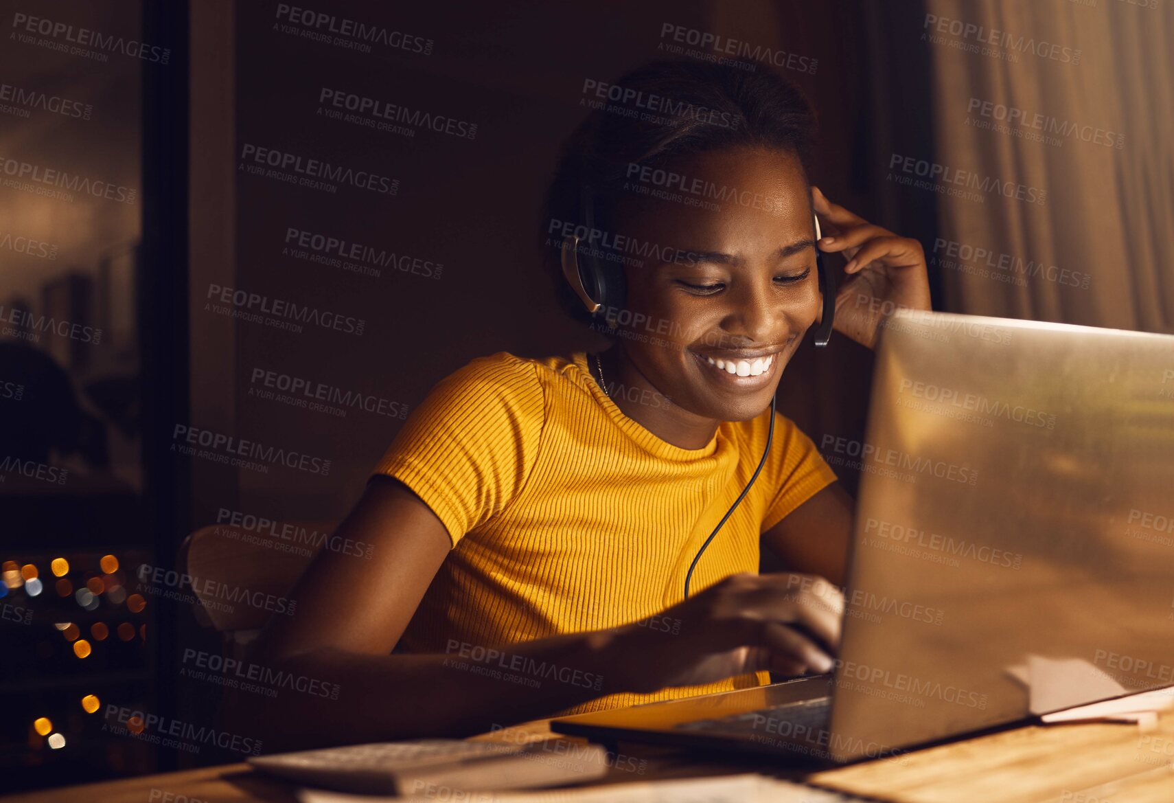 Buy stock photo Young, happy and beautiful woman working while listening to music. Girl making work fun and joyful through entertainment late at night. Smiling, positive female on a laptop sitting at a desk at home.