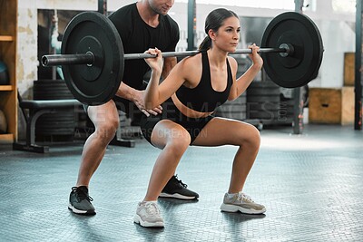 Buy stock photo Active woman bodybuilder training and weight lifting with a personal trainer at the gym. Fit and athletic young female athlete lifts a barbell with her coach at a fitness facility