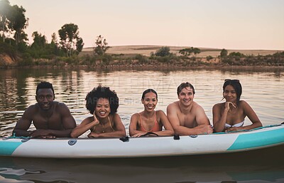 Buy stock photo Diverse group of friends having fun while swimming at a lake in summer with a floating kayak boat. Happy, young and multiracial people on vacation enjoying nature and water on a canoe at sunset.
