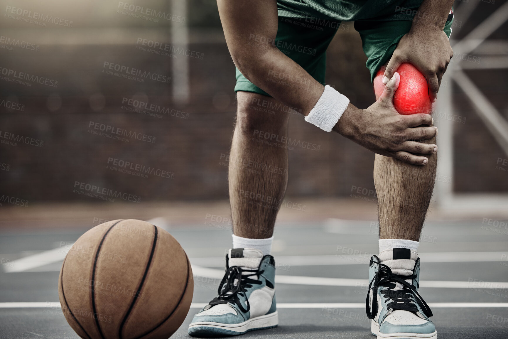 Buy stock photo Sports, injury in basketball and knee pain or athlete man while on an outdoors court holding his hurt leg during training or exercise for hobby. Closeup of male hands on glowing red body part