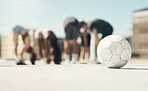 Football, soccer ball and sports group of men and women exercise, training and workout on urban rooftop. Street ball, concrete training and fitness people for team practice for game or competiton