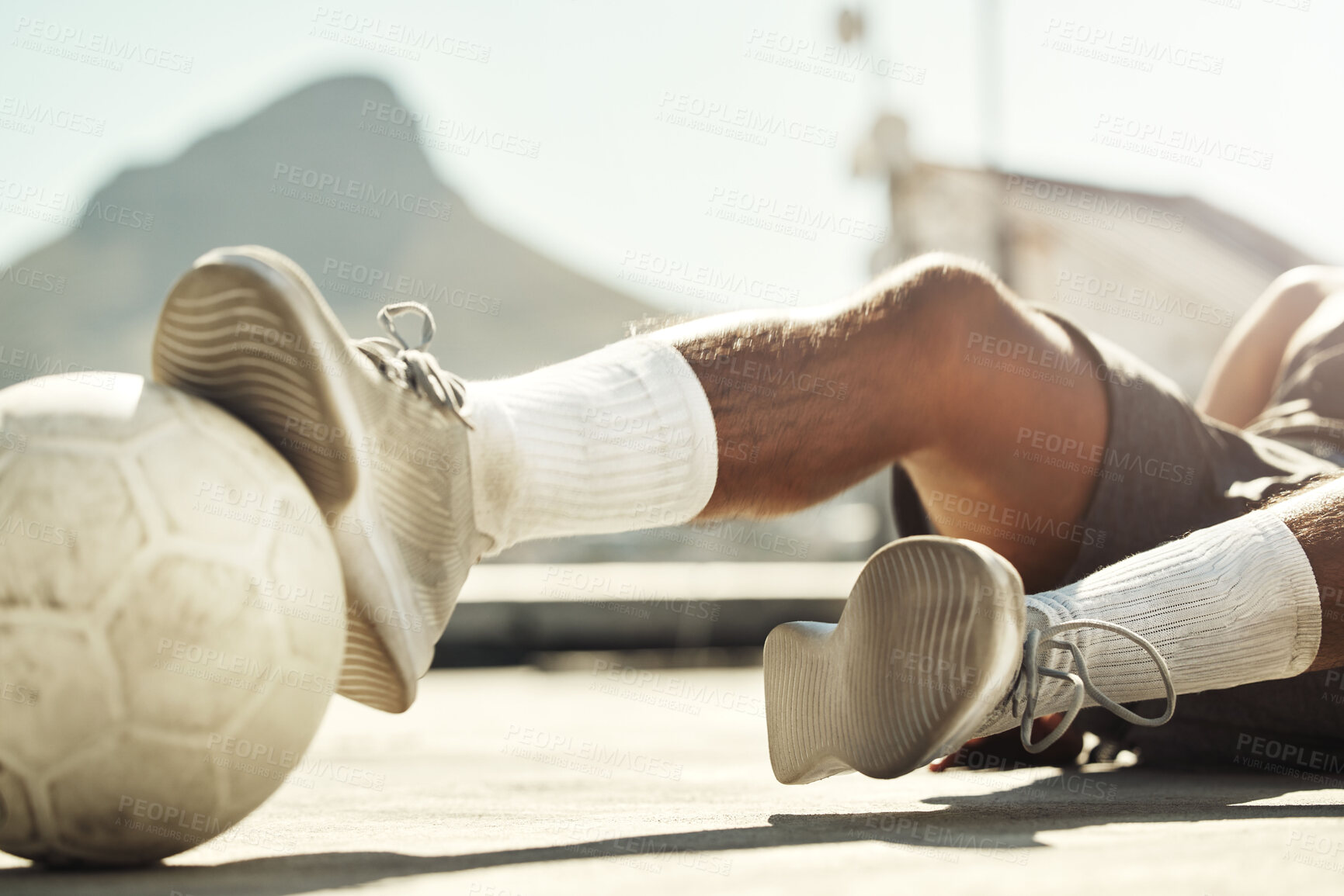 Buy stock photo Soccer, ball and man with slide challenge during match, practice or training on concrete court in the city. Football, fitness and exercise in sports game with athlete legs, shoes and tackle outdoor