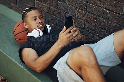 Buy stock photo Basketball player, phone and fitness app on break after sports match, game or practice with ball and black man outdoor. Male fitness athlete with 5g network on social media after sport and exercise 