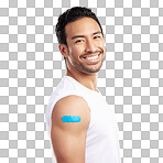 Handsome young mixed race man showing off his covid 19 jab while standing in studio isolated against a blue background. Hispanic male with a plaster on his corona virus vaccination injection site