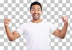 Handsome young mixed race man celebrating victory or success while standing in studio isolated against a blue background. Hispanic male cheering and pumping his fists at success or achievement