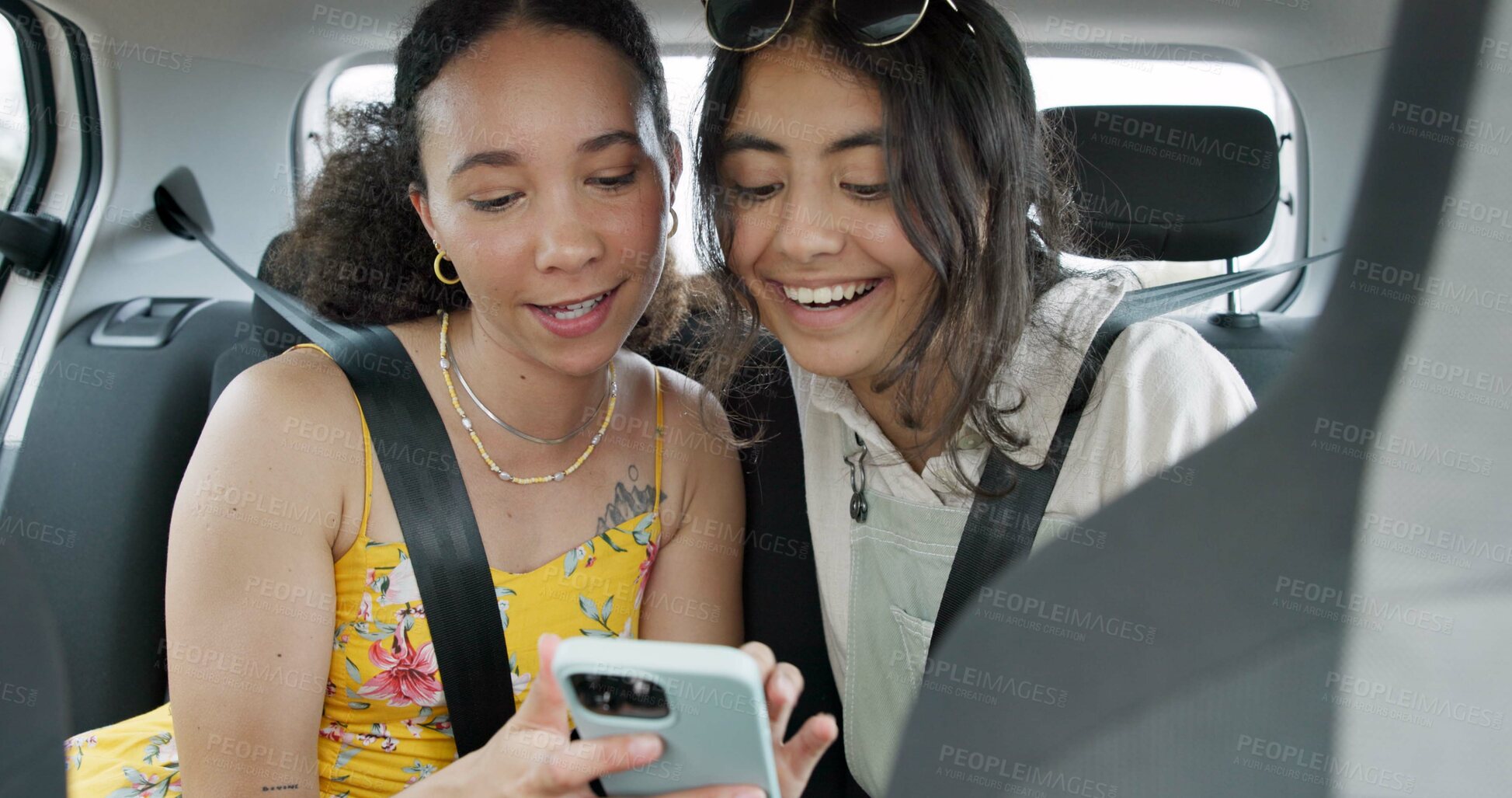 Buy stock photo Happy friends, phone and car for road trip information, location search and social media. Young women reading on mobile app and talking of travel, holiday and transportation service with funny chat