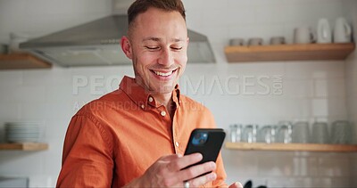 Man, kitchen and typing on phone or browsing social media at home, happy and relaxing on weekend. Happy male person, communication and mobile application for online conversation, humor and laughing