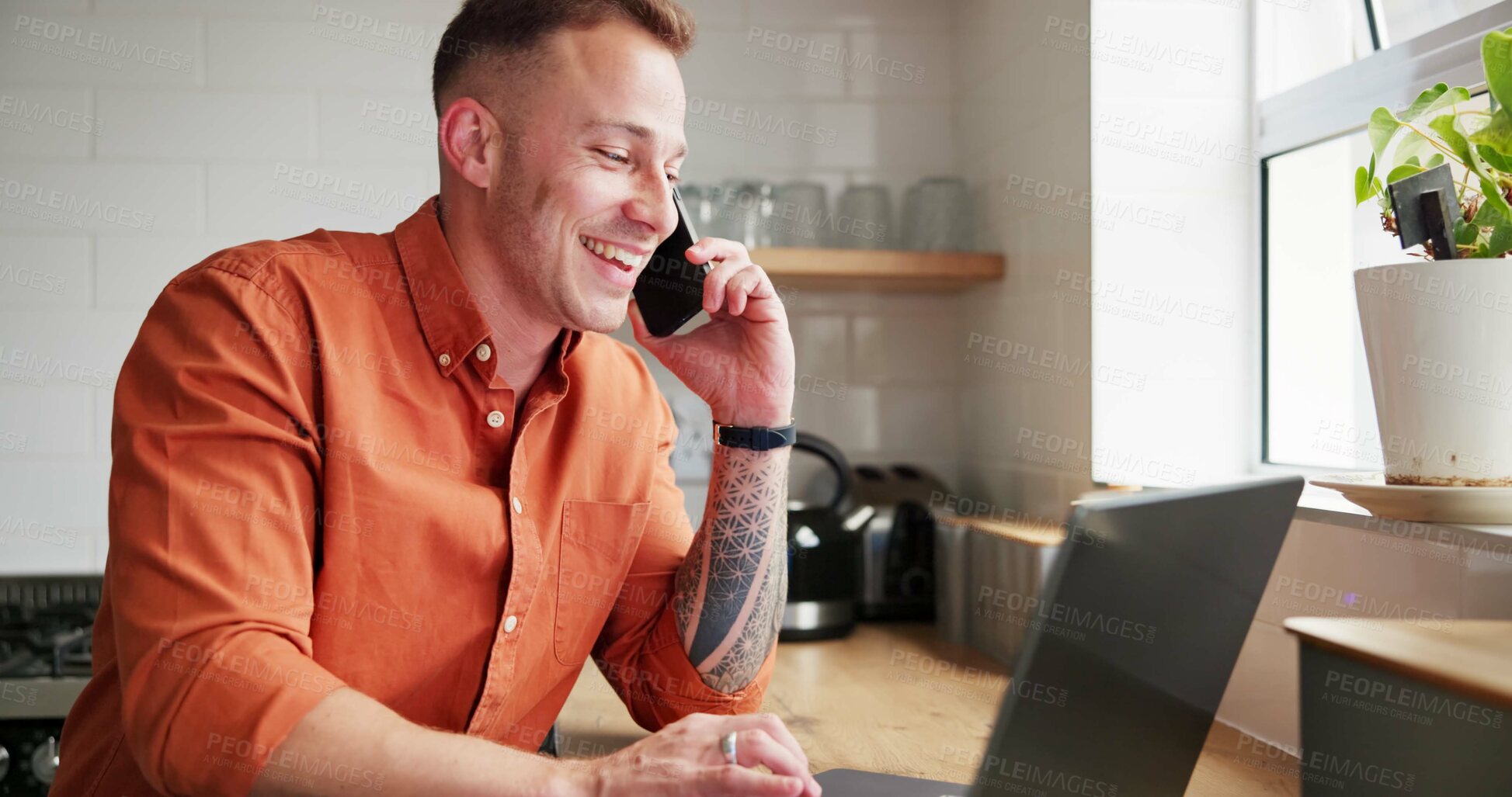 Buy stock photo Happy man, laptop and phone call in remote work for conversation or business in kitchen at home. Male person or freelancer smile talking on mobile smartphone with computer for discussion at house