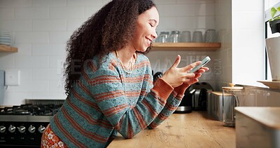 Woman, kitchen and typing on phone or browsing social media at home, happy and relaxing on weekend. Female person, communication and mobile application for online conversation, humor and laughing