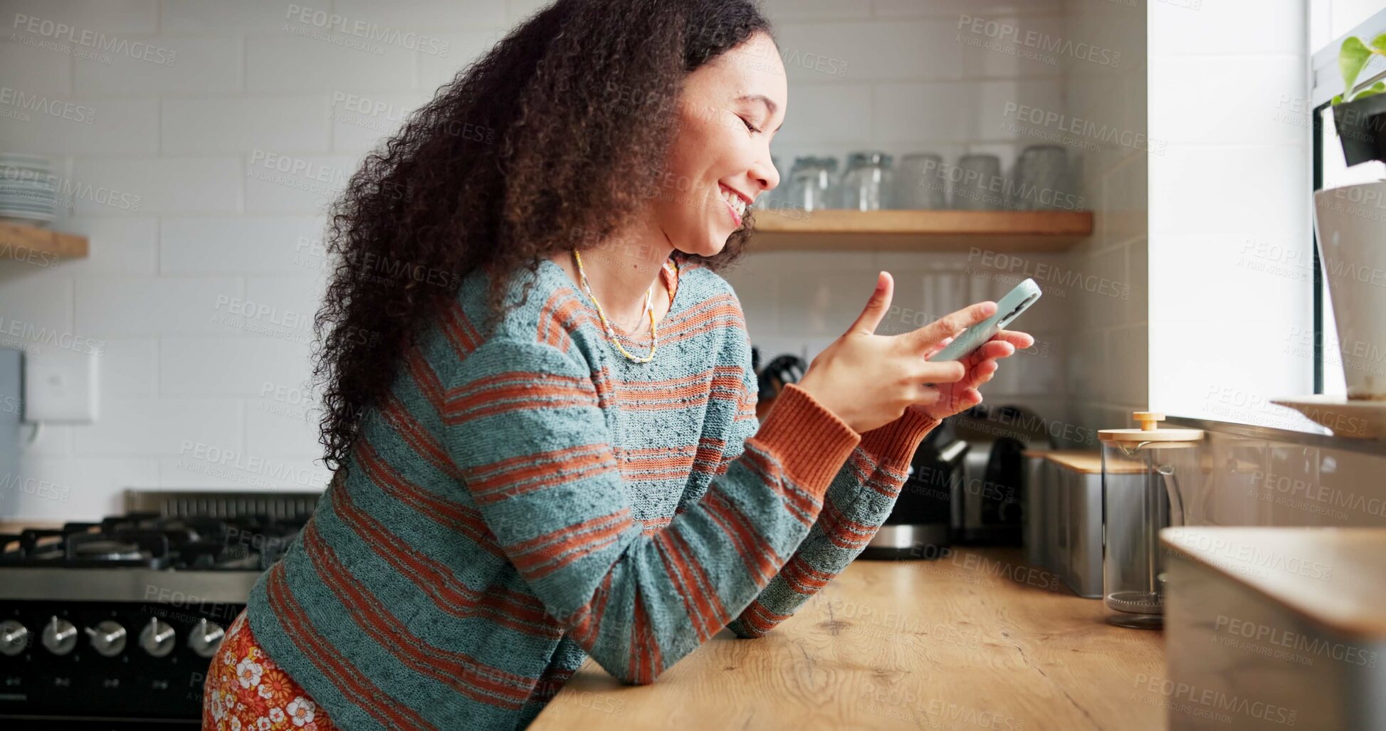 Buy stock photo Woman, kitchen and typing on phone or browsing social media at home, happy and relaxing on weekend. Female person, communication and mobile application for online conversation, humor and laughing
