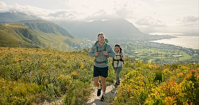 Couple of friends walking, hiking on mountain and travel for fitness, adventure or journey in nature for wellness. Young people trekking with backpack on a path or green hill for cardio and health