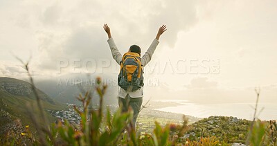 Person, mountain top and freedom or celebration of hiking goals, travel or trekking adventure in nature. Back of hiker or winner in backpack and arms up for success, achievement or excited on a cliff