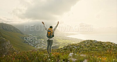 Woman, hiking on mountain top and freedom or success of travel goals, trekking adventure and nature. Back of hiker or winner in backpack and arms up, celebration or achievement on cliff and cityscape
