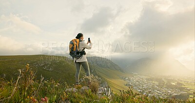 Woman, trekking and video recording on mountains in adventure, wellness and health with nature and cityscape. Person with backpack and hiking photography on green hill, travel or eco friendly journey