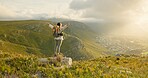 Woman, mountain top and freedom, hiking goals, celebration or travel achievement in nature adventure. Person or winner in backpack with arms up for trekking success, energy and yes on a cliff or rock