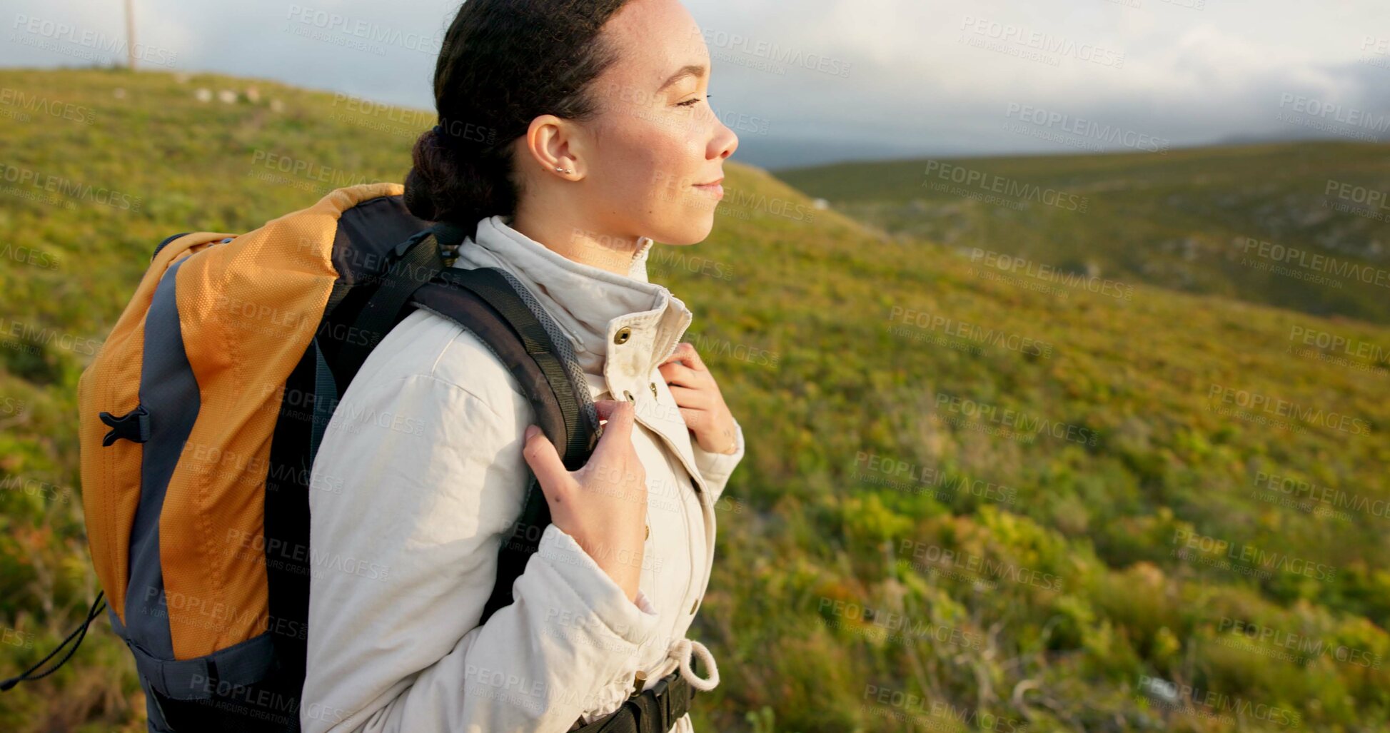 Buy stock photo Young woman, hiking on mountain and breathing fresh air for outdoor wellness, fitness and health. Happy person in wind with backpack and trekking in nature on a hill for adventure, travel or journey