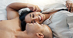 Happy couple, bed and talking of love, intimacy and romance at home for relationship and bonding. Young woman and man hug and relax in bedroom for marriage, kiss and wake up together in apartment