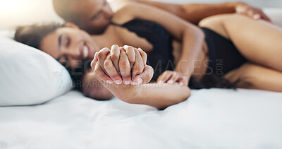 Couple, holding hands and wake up in bed with happy, love and support together in a hotel. Bedroom, trust and bonding with marriage and commitment of people with a smile from relax and calm morning