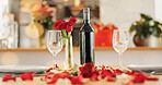 Wine, flowers and romance on valentines day for celebration of love, anniversary or honeymoon in still life. Glass, dinner and elegant date in dining room of home for event, milestone or occasion