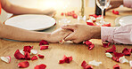 Couple, roses and holding hands on dinner date, anniversary or valentines day dining by table at home. Closeup of man and woman in celebration or care for romantic honeymoon, embrace or love at house