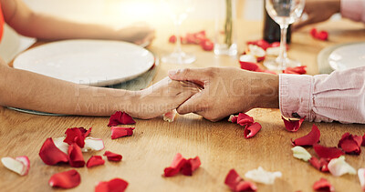 Couple, roses and holding hands on dinner date, anniversary or valentines day dining by table at home. Closeup of man and woman in celebration or care for romantic honeymoon, embrace or love at house