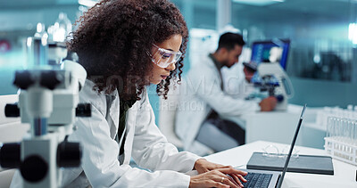 Scientist, woman and microscope with computer for laboratory research, test and DNA investigation at night. Professional doctor or science expert with lens check, laptop and particles for inspection