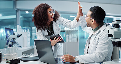 Science, teamwork and high five with laptop in laboratory for test breakthrough, pharmaceutical review or excited. Scientist, collaboration or mentor for research success, talking or digital analysis