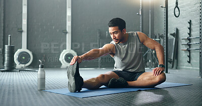Man, break and stretching on gym floor in fitness, workout or training for strong muscles, heart health or cardio wellness. Japanese personal trainer, sports person or coach in body warmup exercise