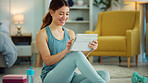 Fitness, internet and woman streaming on a tablet for training, yoga and exercise on the floor of her house. Happy, young and wellness girl with technology for a workout, cardio or video on pilates