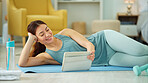 Fitness, internet and woman streaming on a tablet for training, yoga and exercise on the floor of her house. Happy, young and wellness girl with technology for a workout, cardio or video on pilates