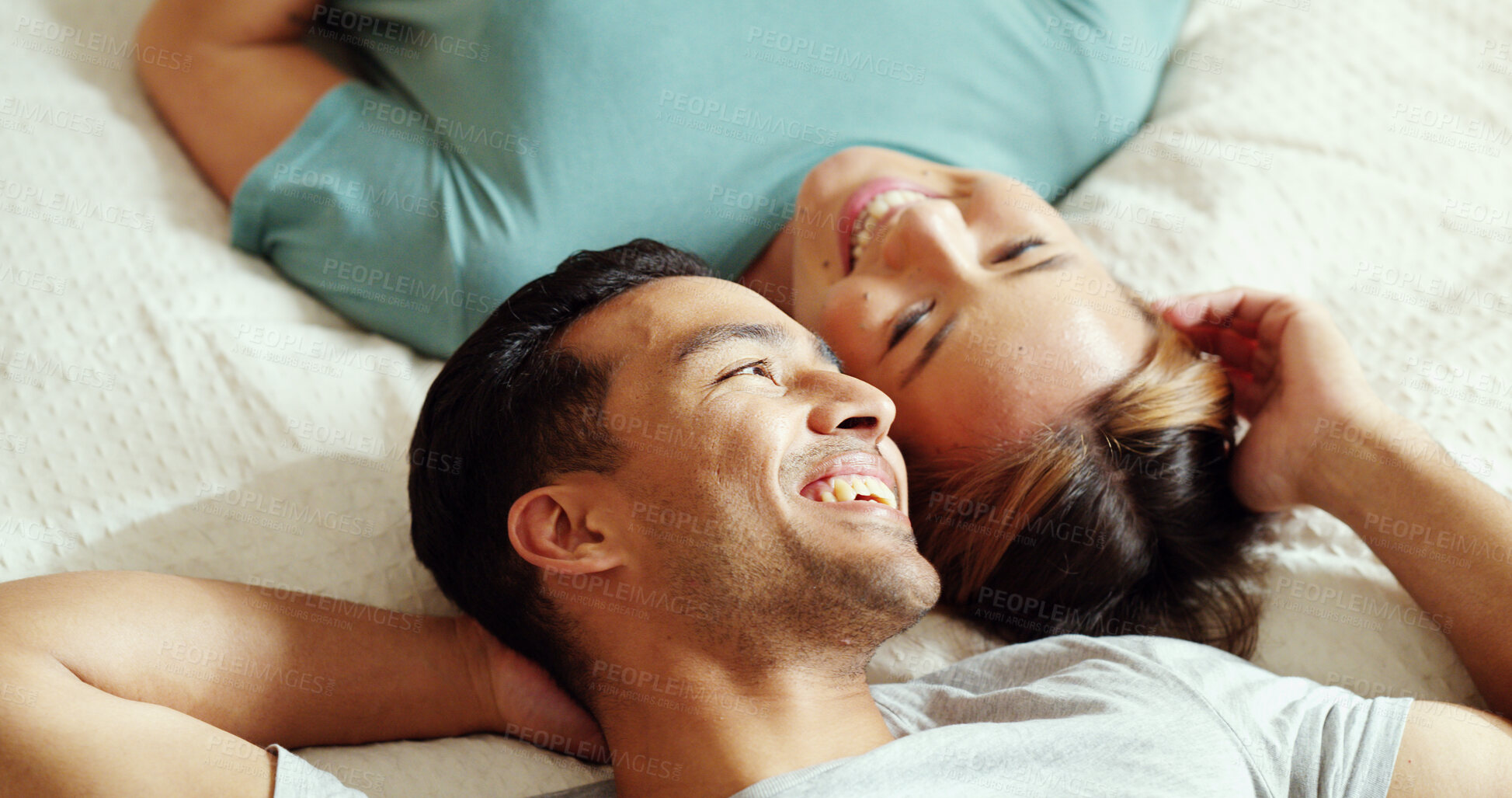 Buy stock photo Happy couple, bedroom and talking while lying on bed for love and marriage bonding happiness in comfy home. Asian man and woman joke and relax in romantic hotel together in morning from above