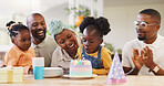 Birthday, children party and applause with a family in celebration of a girl child in their home. African parents, grandparents and kids clapping while blowing candles on a cake at a milestone event