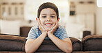 Happy, cute and face of a child on the sofa for playing, relax and weekend fun. Smile, youth and portrait of a little boy kid with an adorable expression, charming and on vacation on the couch