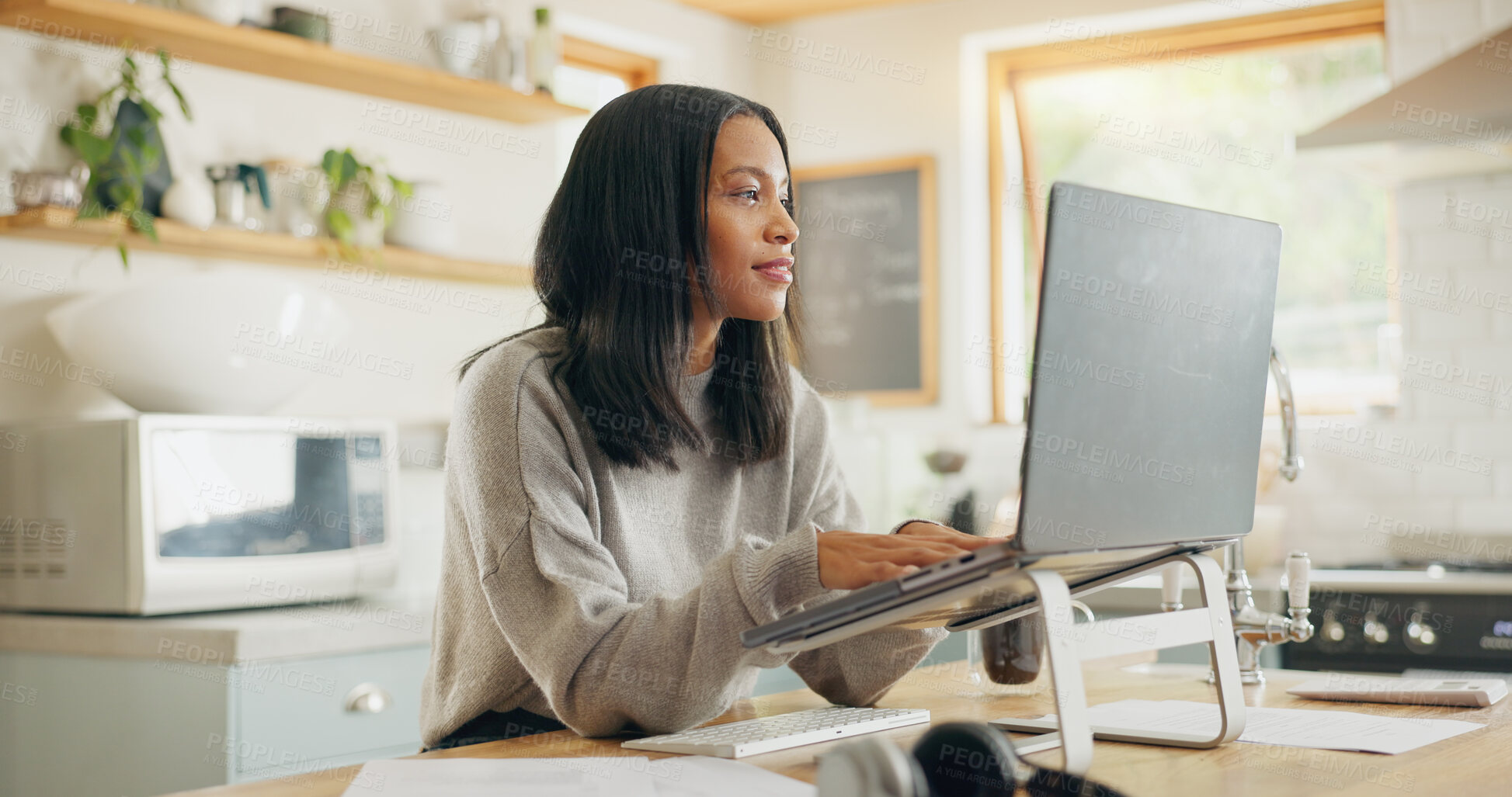 Buy stock photo Laptop, documents and remote work with a woman entrepreneur in the kitchen of her home for small business. Computer, report and a young female freelance employee working on a startup from her house