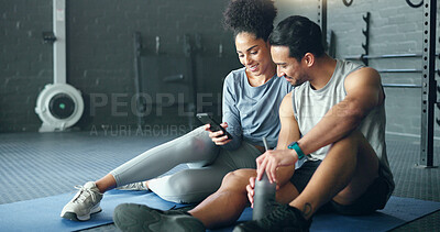 Smartphone, fitness and personal trainer talking to client for exercise goal planning on mobile app, internet search or health software. Young sports people on floor in conversation and using phone