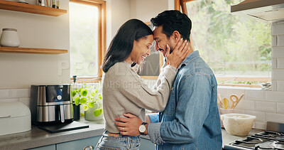 Hug, happy and couple in a kitchen bonding, intimate and talking in their home together with intimacy. Love, face and woman embrace man with smile, care and sharing romantic moment and conversation