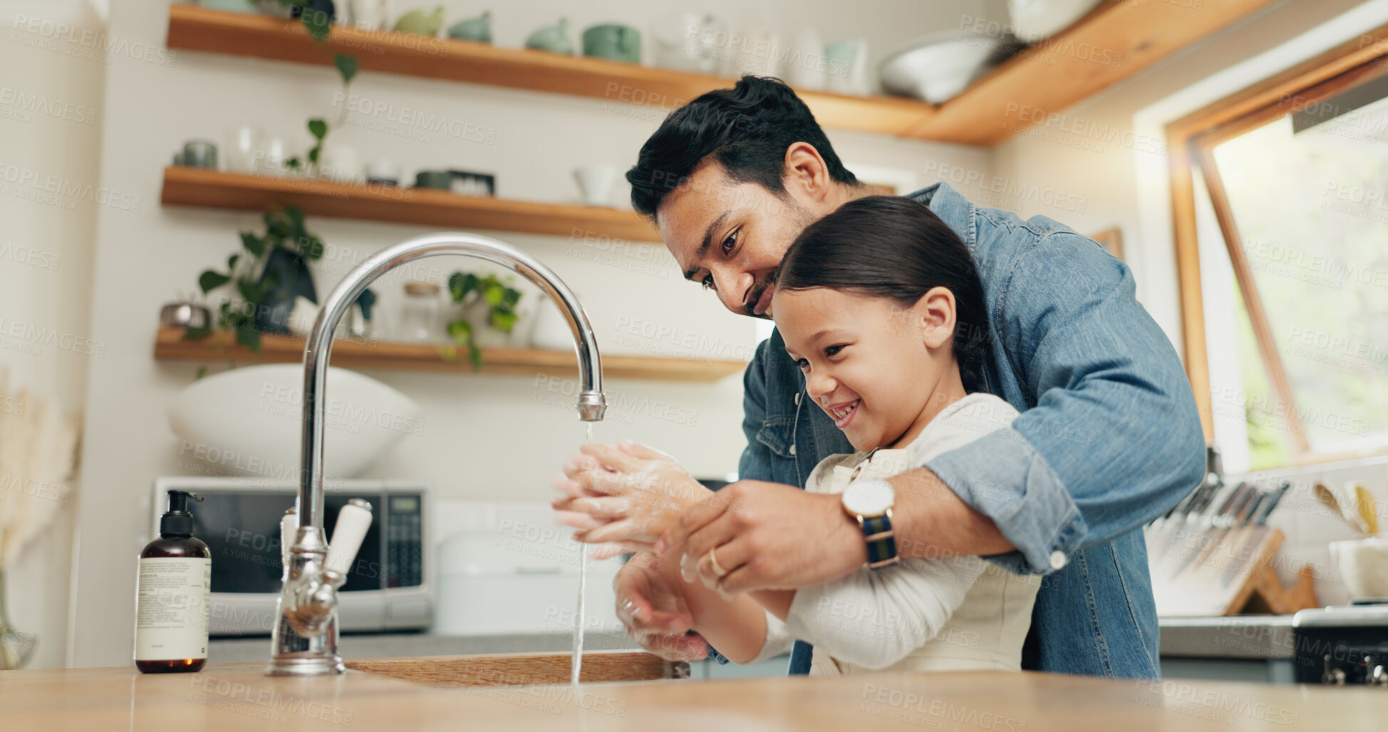 Buy stock photo Girl washing her hands with her father in the kitchen for hygiene, health and wellness at home. Child learning to clean her skin with young dad with soap and water to prevent germs, dirt or bacteria.