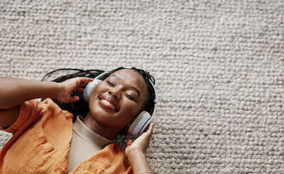 Home, music and black woman on a couch, headphones and streaming audio in a living room. African person on a sofa, apartment or girl with headset, listening to sound and relax with happiness or song
