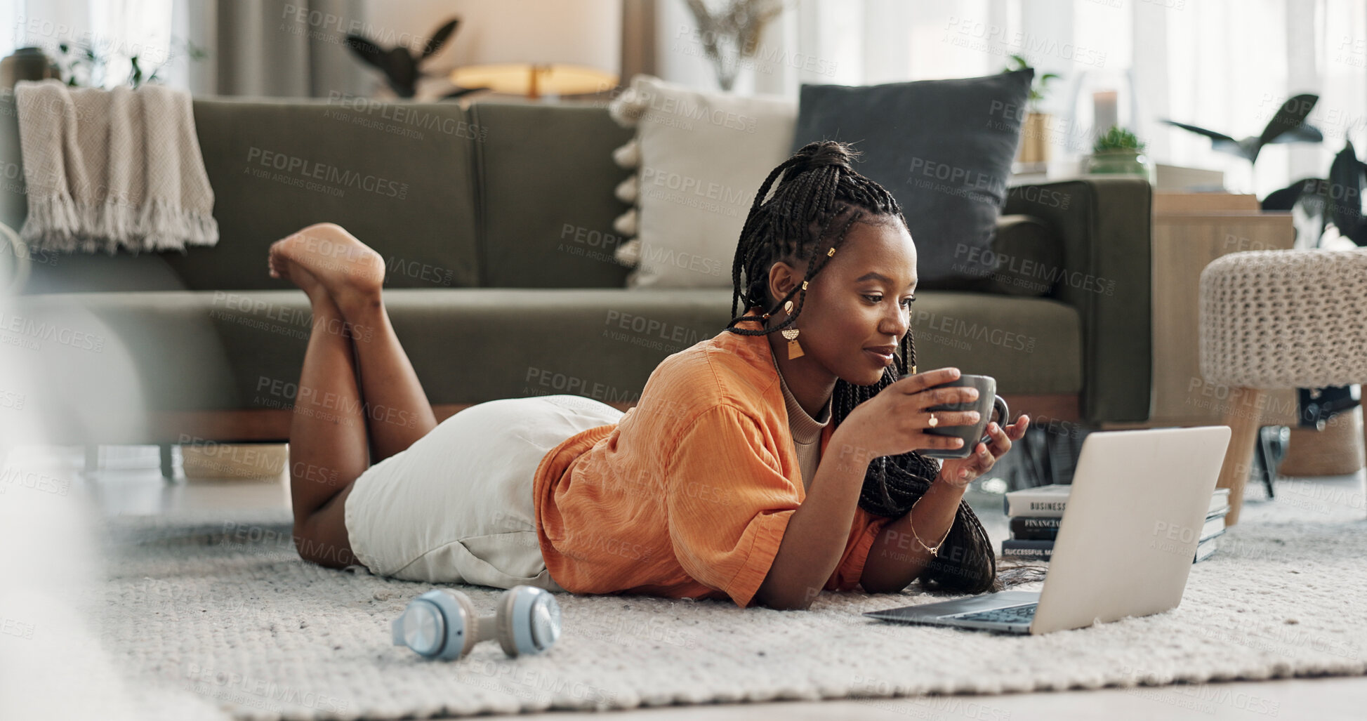 Buy stock photo Laptop, coffee and woman on the floor in living room of modern apartment reading information. Technology, relax and young African female student study and drink latte on computer in lounge at home.