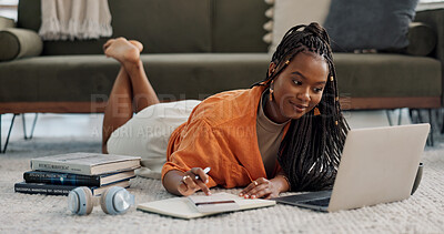 Laptop, happy and woman writing notes on the floor in the living room of modern apartment. Technology, smile and young African female university student studying on a computer in the lounge at home.