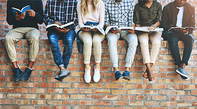 Buy stock photo Cropped shot of a group of unrecognizable university students studying while sitting outside on a facebrick wall