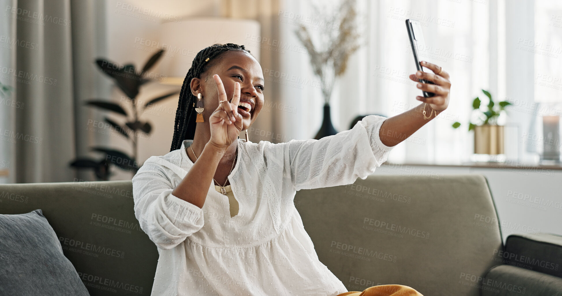 Buy stock photo Smile, selfie and black woman with peace sign, funny face and relax on sofa in living room. V hand, picture and happy African person or influencer at home on couch on social media with tongue out