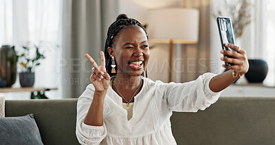 Smile, selfie and black woman with peace sign, funny face and relax on sofa in living room. V hand, picture and happy African person or influencer at home on couch on social media with tongue out