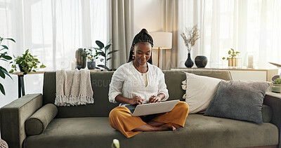 Black woman on sofa, smile and typing on laptop for remote work, social media or blog post research in home. Happy girl on couch with computer checking email, website or online chat in living room.