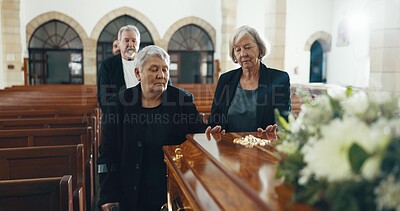 Senior women, coffin and funeral in church for memory, support and condolences with religion with family. Community, friends and together for death, loss and service with empathy, faith and casket