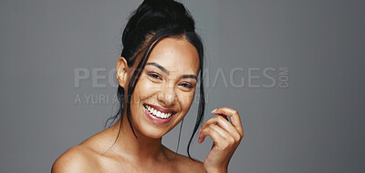 Face, skincare and happy woman wink in studio isolated on a gray background. Portrait, natural beauty and model flirting in spa facial treatment for aesthetic, glow and cosmetic wellness for health