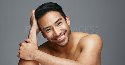 Face, cosmetics and Asian man with skincare, smile and dermatology on a grey studio background. Portrait, Japanese person and happy model with wellness, luxury treatment and beauty with aesthetic
